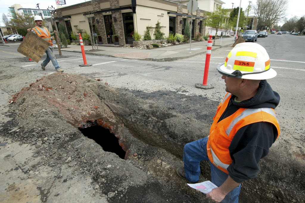 Jimm Grandstaff, left, with Integrity Excavation and Construction, and Mike Steuben, with the City of Vancouver Water dept., work near a cistern discovered at 12th and Main in downtown Vancouver.