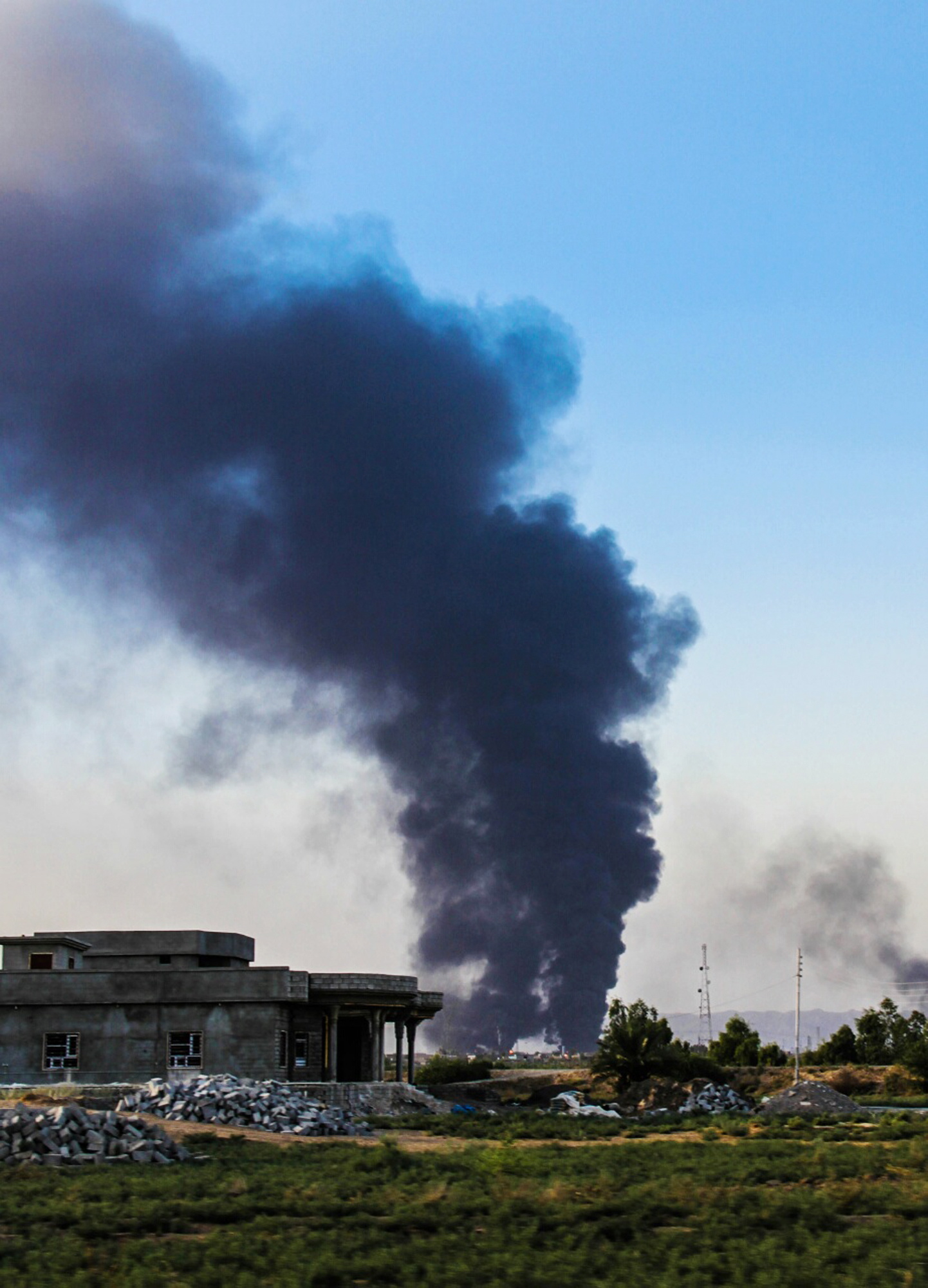 A column of smoke rises from an oil refinery in Beiji, some 250 kilometers north of Baghdad, Iraq, after an attack by Islamic militants on July 31.