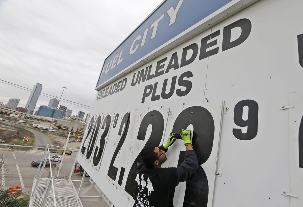 Luis Vargas changes the gas price sign at the Fuel City gas station in Dallas on Dec. 17. Oil's rapid decline in the second half of the year has pushed gas to below $3 a gallon in the U.S., the lowest price in nearly five years, and has also cut the price of other fuels.