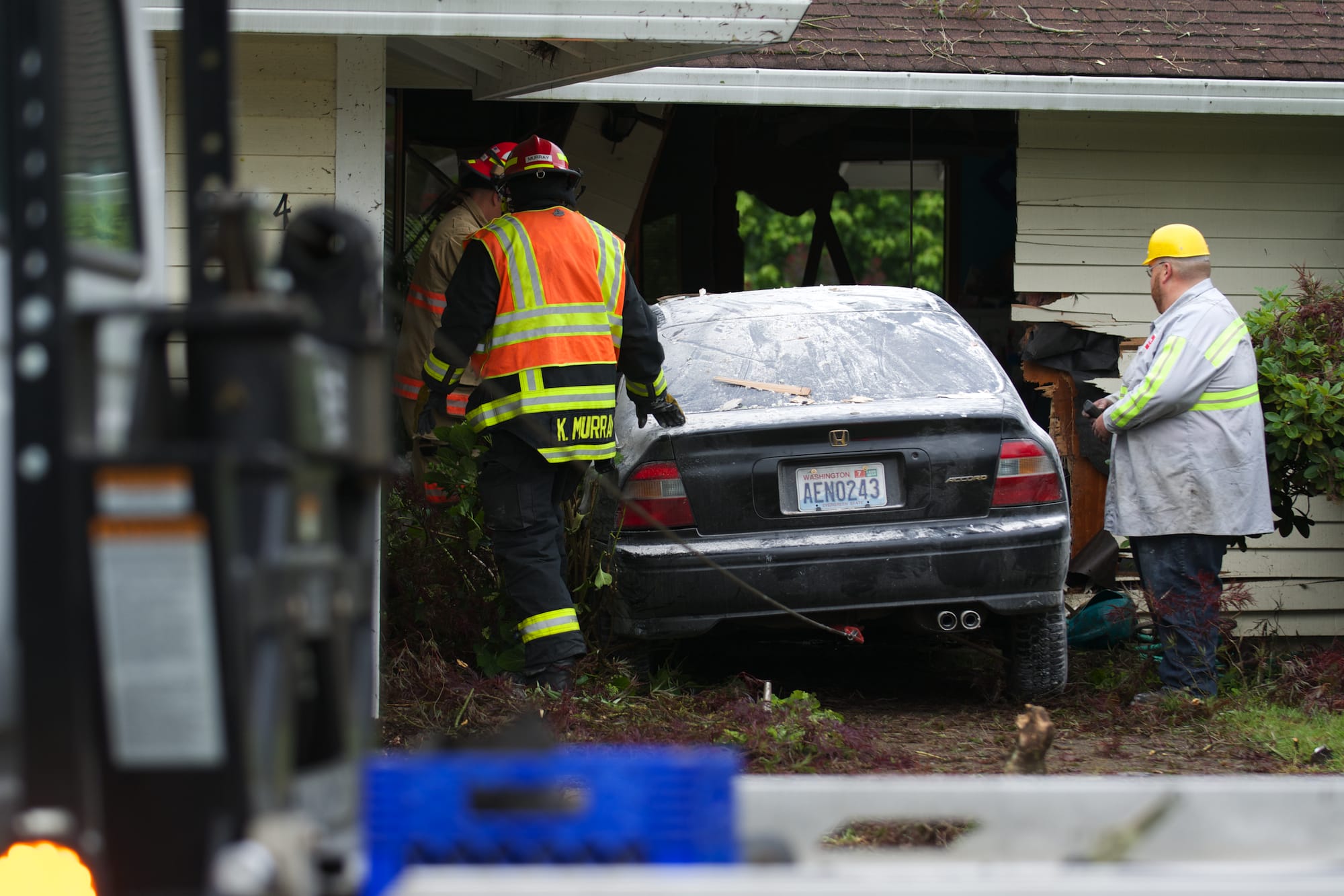 Crews work to remove a car that plowed into an east Vancouver house in the early morning hours on Wednesday, June 18, 2014.