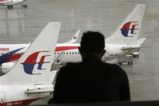 A visitor looks out from the viewing gallery as Malaysia Airlines aircraft sit on the tarmac at the Kuala Lumpur International Airport  in Sepang, Malaysia, on Tuesday.