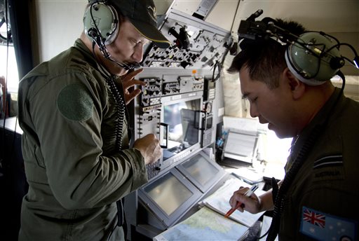 Crew members aboard a Royal Australian Air Force AP-3C Orion aircraft observe navigation maps as they search for missing Malaysian Airlines flight MH370 over the southern Indian Ocean, Thursday. Planes and ships searching for debris suspected of being from the downed Malaysia Airlines jetliner failed to find any Thursday before bad weather cut their hunt short in a setback that came as Thailand said its satellite had spotted even more suspect objects.