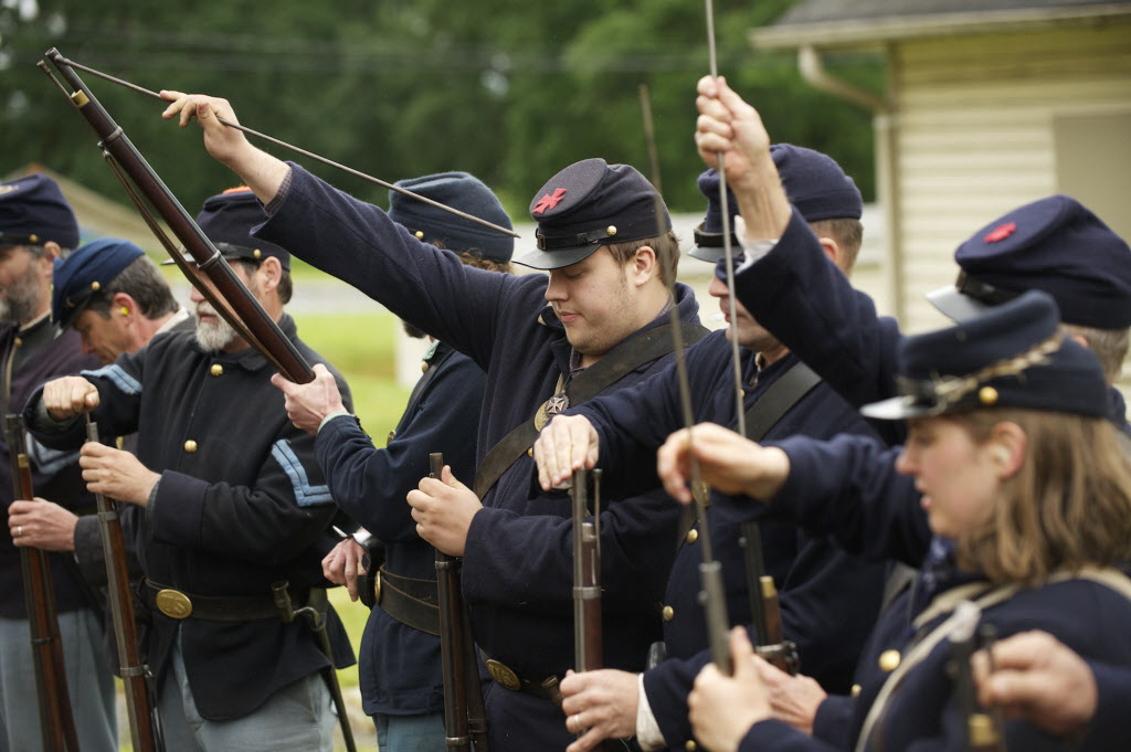 1st Oregon Volunteer Infantry reenactors load their rifles during a soldiers bivouac demonstration at Vancouver Barracks.
