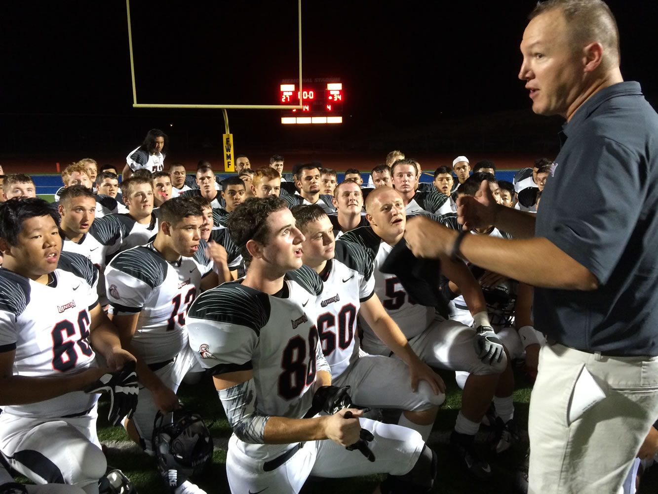 Coach Gary McGarvie talks to his players after Union beat Federal Way 34-27 in his debut as Union's head coach on Saturday.