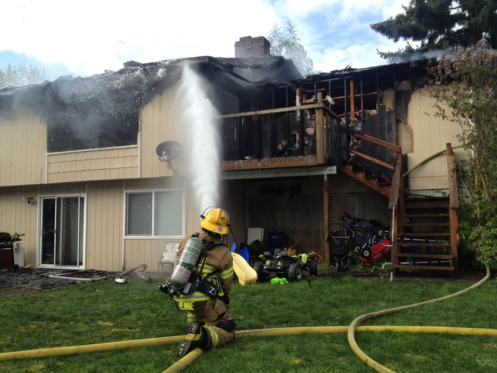 A firefighter sprays down a home in Hazel Dell that caught on fire.