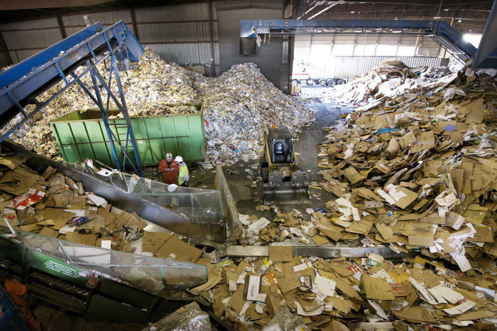 This November 2013 photo shows workers at West Vancouver Materials Recovery Center sorting through tons of cardboard, paper and other recycled materials.