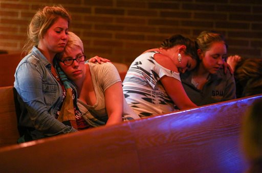Annalyse Hurd, left, and Olivia Hutton, center, pray at the First Free Methodist Church after a shooting at Seattle Pacific University on Thursday. A man that shot students was disarmed by others at the scene.