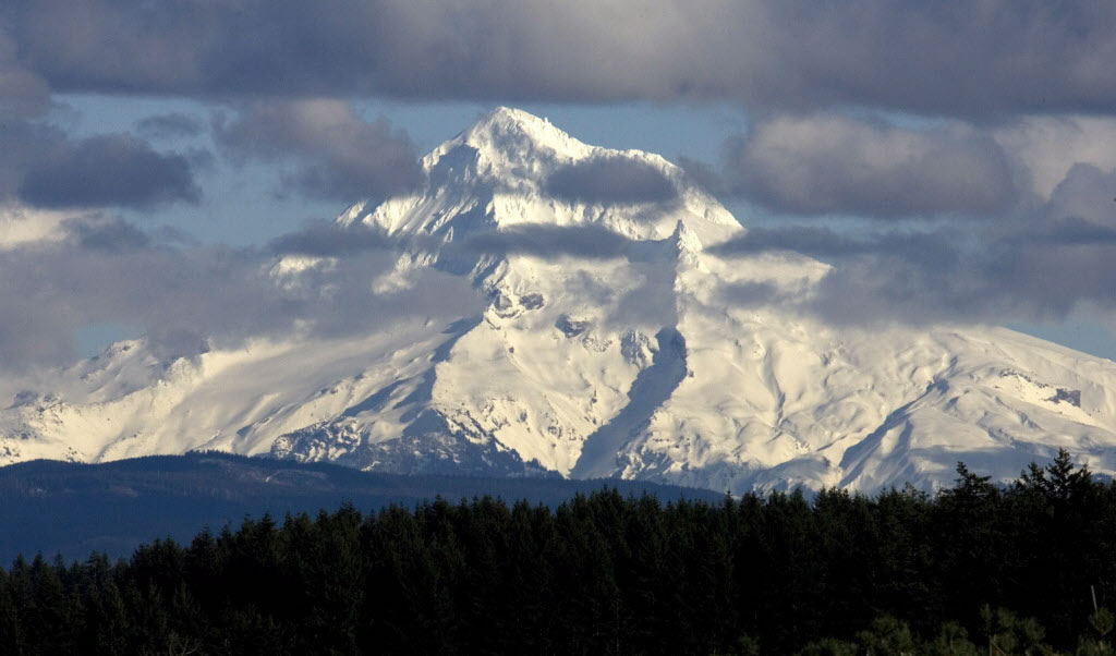 Clouds glide across the west face of Mount Hood as seen near Boring, Ore.