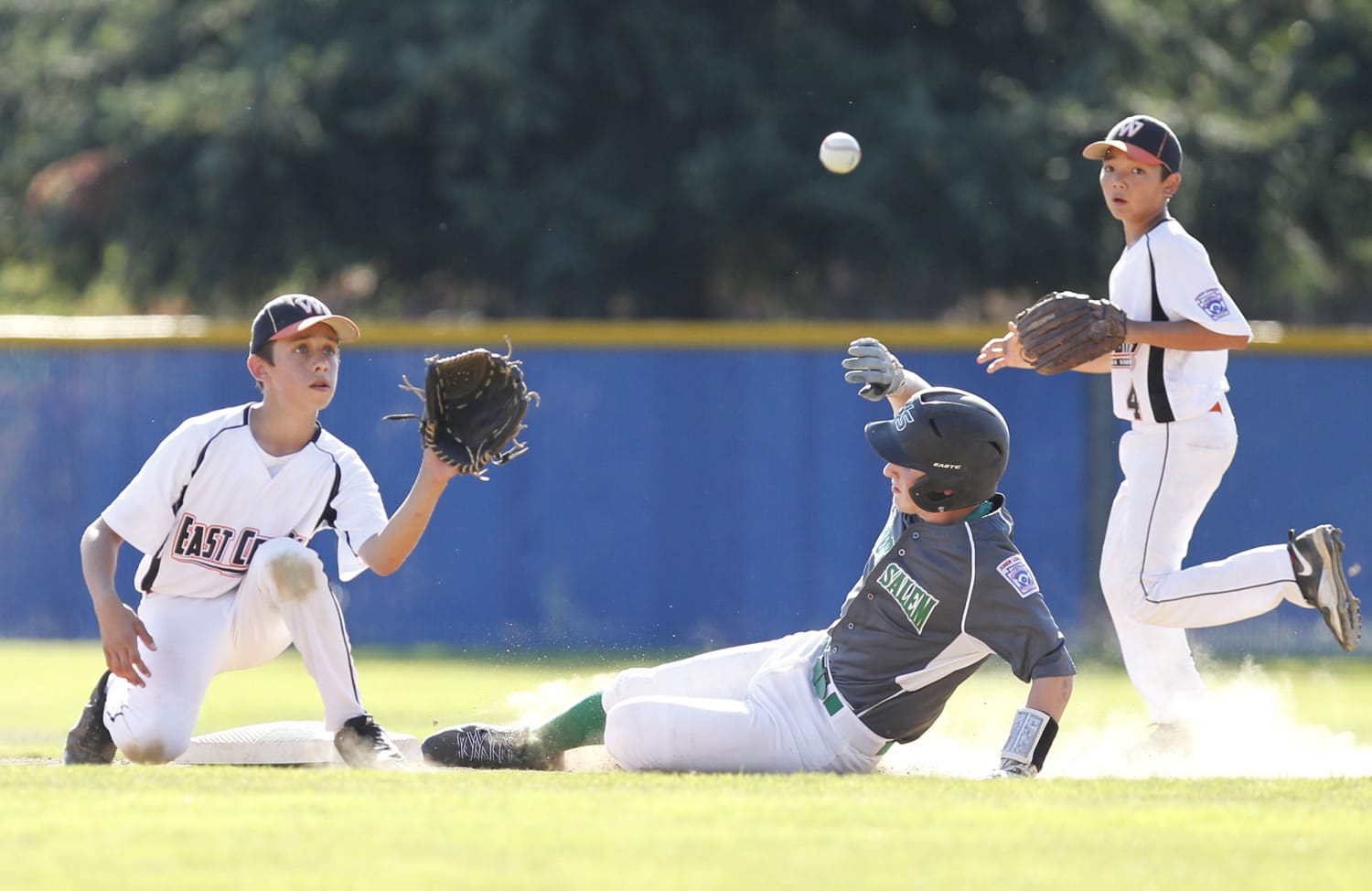 East County's Alex Orr, left, awaits the throw against a West Salem runner in the Little League Junior Boys Western Region tournament, played at Clark College in July 2014.