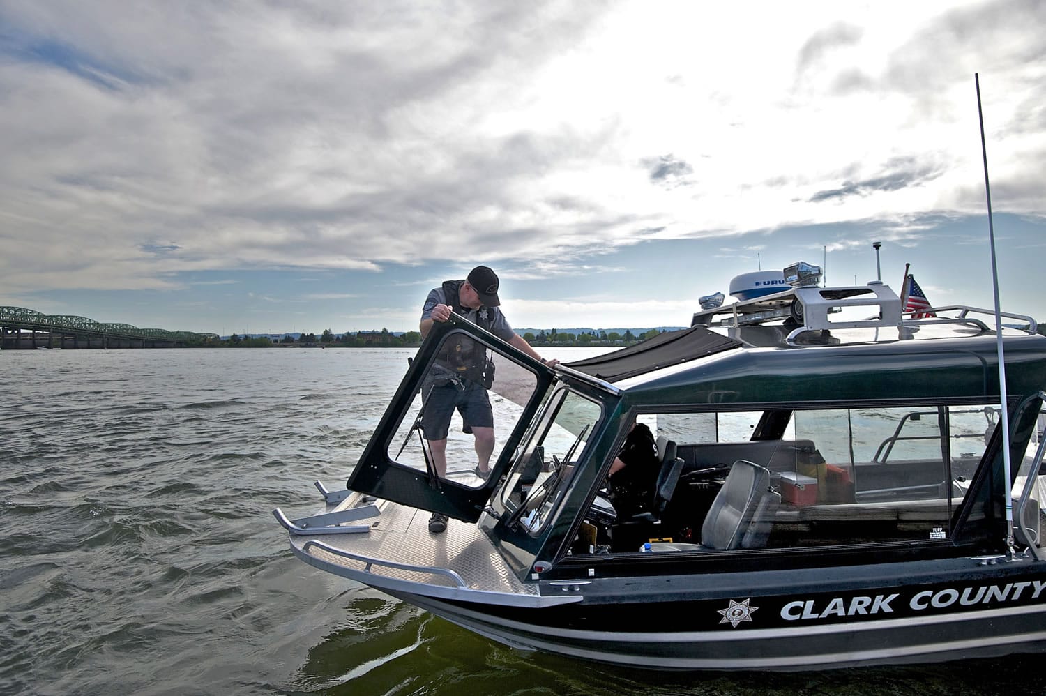 Clark County Sheriff&#039;s deputy Kevin Gadaire climbs back inside the marine patrol boat while patrolling the Columbia River in 2014.