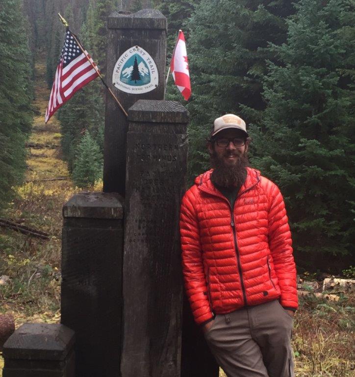 Anthony Mannello stops for a photo at the U.S.-Canadian border on the Pacific Crest National Scenic Trail.