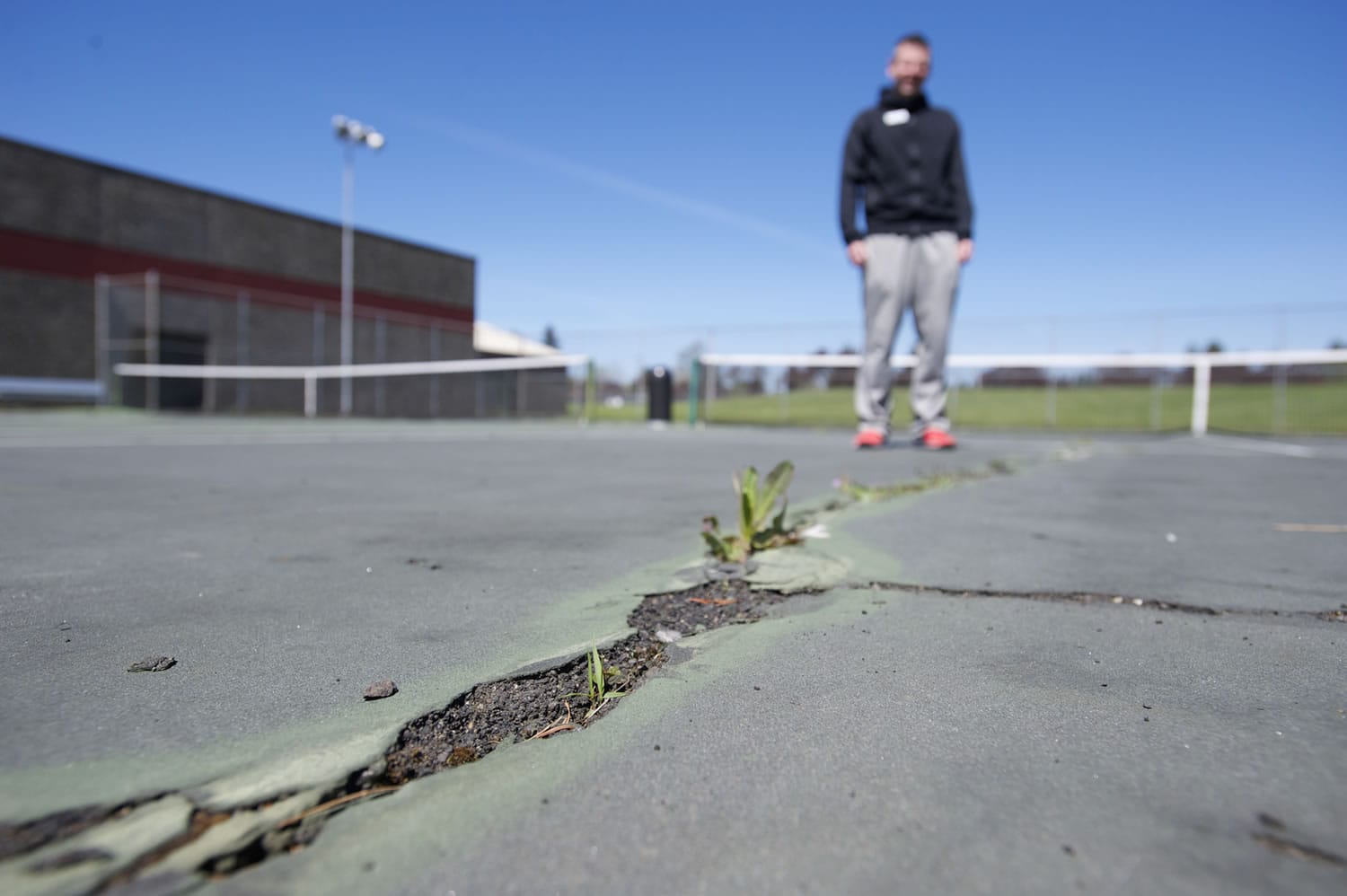 Vancouver Tennis Center manager Brent Waddle shows large cracks on the outdoor courts, Thursday, April 16, 2015.