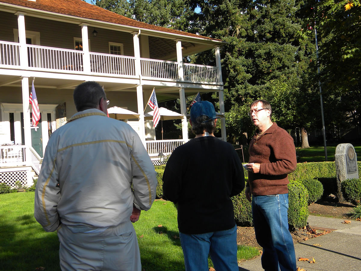 Jeff Davis, right, tells members of a tour group about mysterious events at the Grant House on Officers Row.