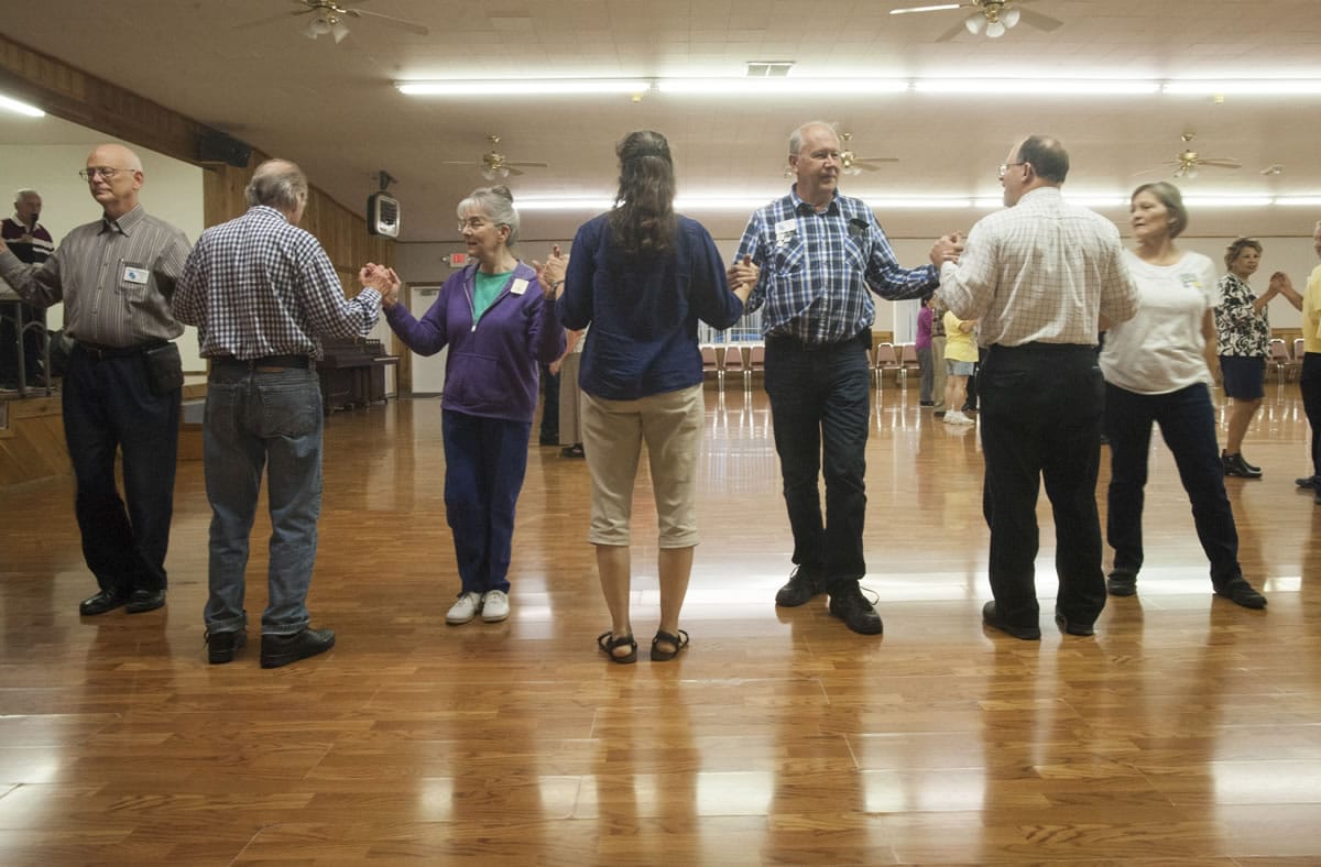 Square dancers join hands while practicing their moves at the Clark County Square Dance Center in Brush Prairie.