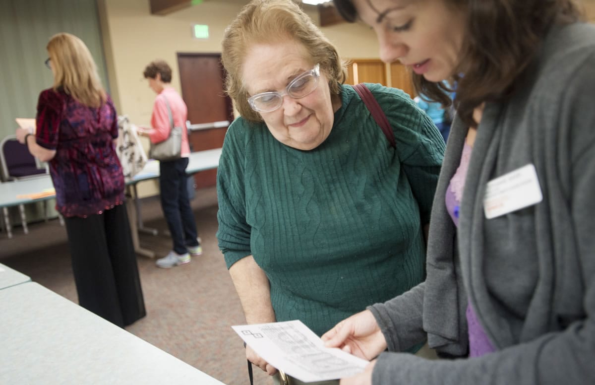 Sharon Gutz, left, gets some help reading small type from Stephanie Barr as Gutz participates in a workshop at the YWCA on Tuesday evening. The event puts people in the shoes of domestic violence victims.