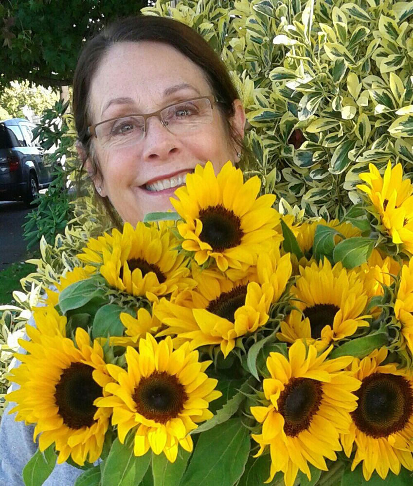 Everett florist Paula Adrian poses with sunflowers in this photo she provided to The Columbian on Sept. 24.