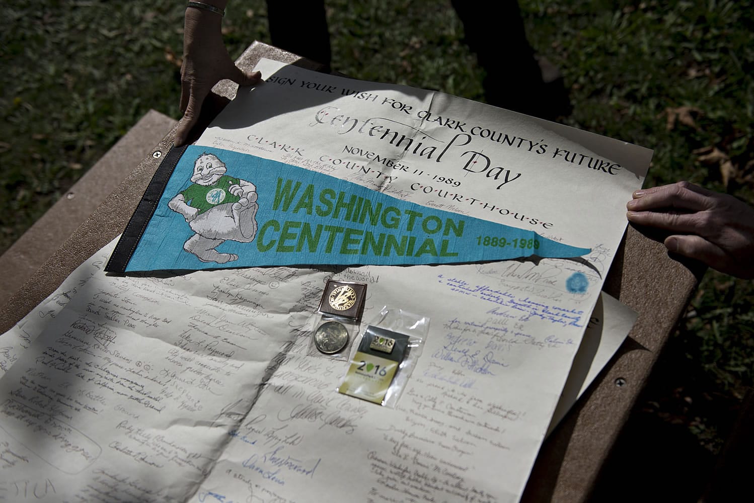 Items from a 1989 time capsule are displayed along with a 2016 National Park Service Centennial pin to be put into the new time capsule, which will be buried at the foot of the relocated monument.