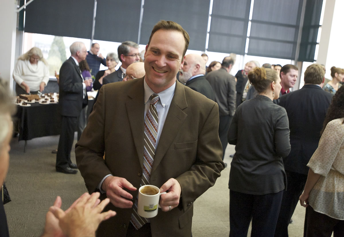 Clark County Commissioner Steve Stuart, bearing his unwashed coffee cup, greets well-wishers at a farewell open house in his honor Thursday.