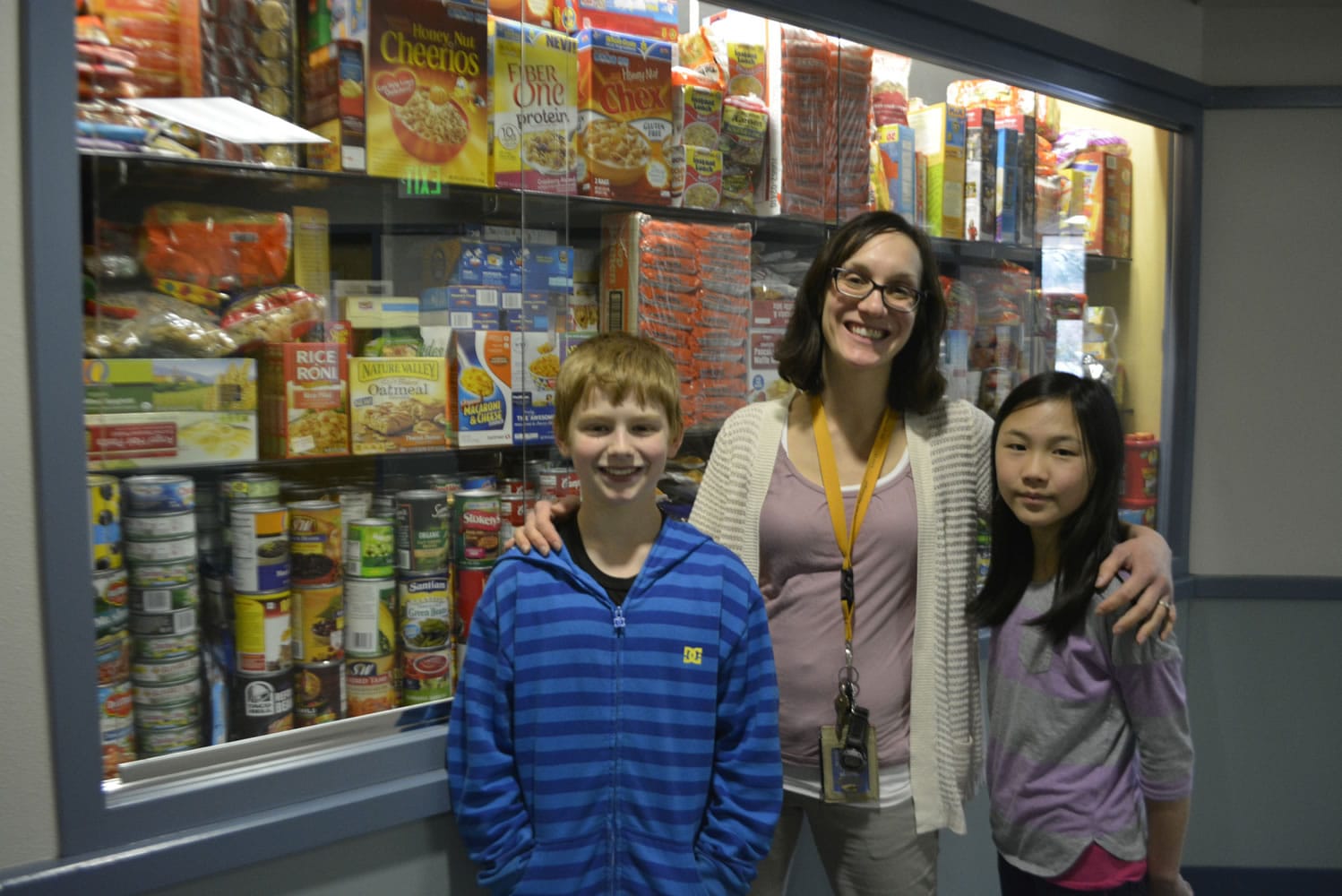 Washougal: Julie Bristol, Gause Elementary School social worker, stands with student helpers Jackson Rauch, left, and Milan Shirakawa in front of food donated to the Weekend Backpack Program.
