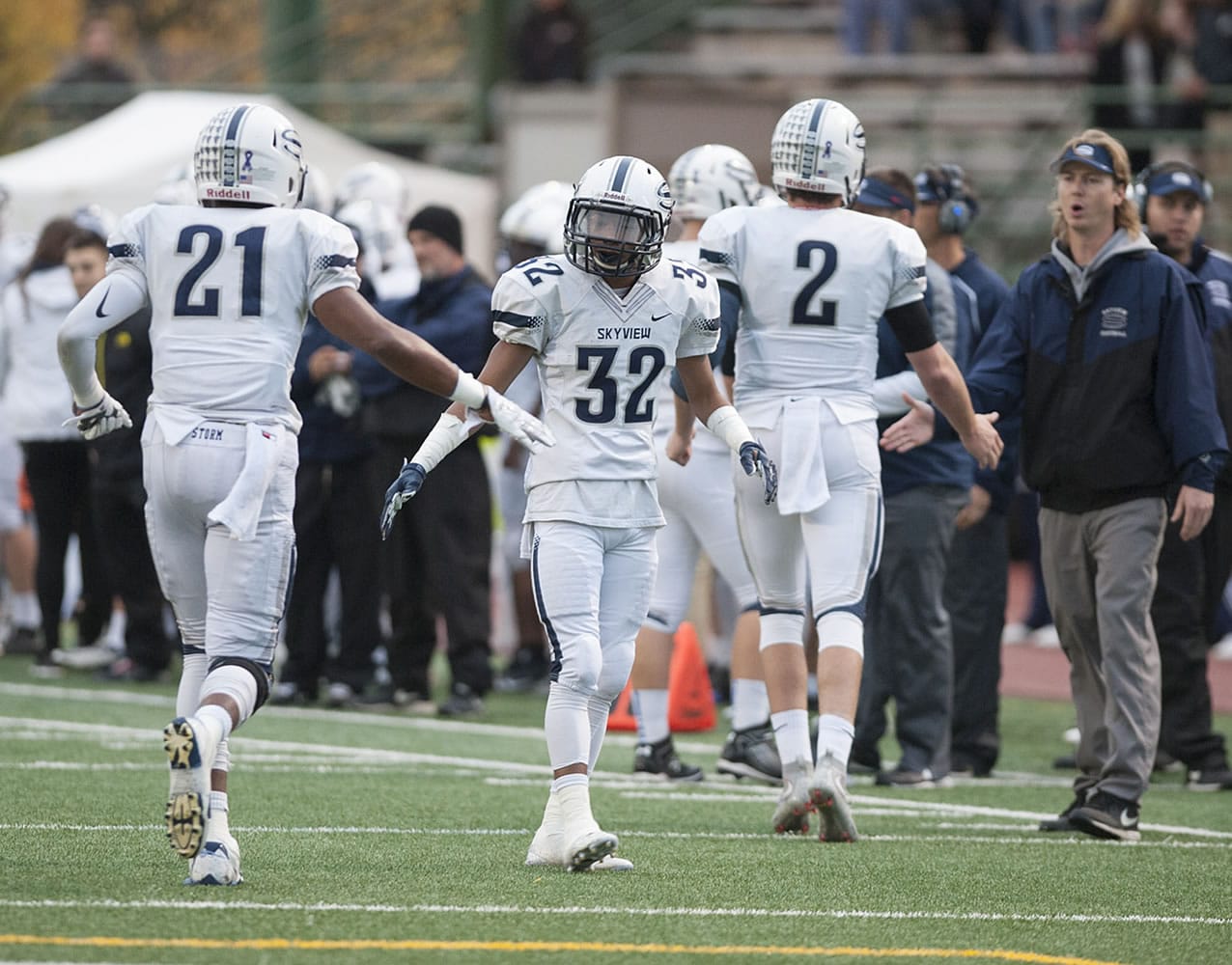 Skyview's Jeremiah Wright (21) celebrates his second quarter touchdown with teammate Tavis Chunphakvenn-Pinkney (32) on Friday. Skyview, Battle Ground and Mountain View will play a tiebreaker Monday to decide two postseason berths.