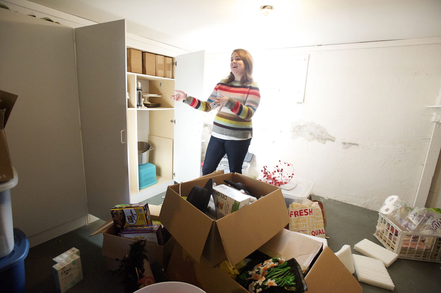 Professional organizer Megan Vaughn opens a cupboard in her basement catch-all room to reveal three punch bowls. &quot;Who needs three punch bowls?&quot; she asked.