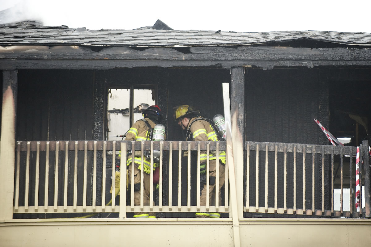 Fire fighters clean up a fire that destroyed an apartment complex at the Bridge Creek apartments Sunday March 16, 2014 in Vancouver, Washington.