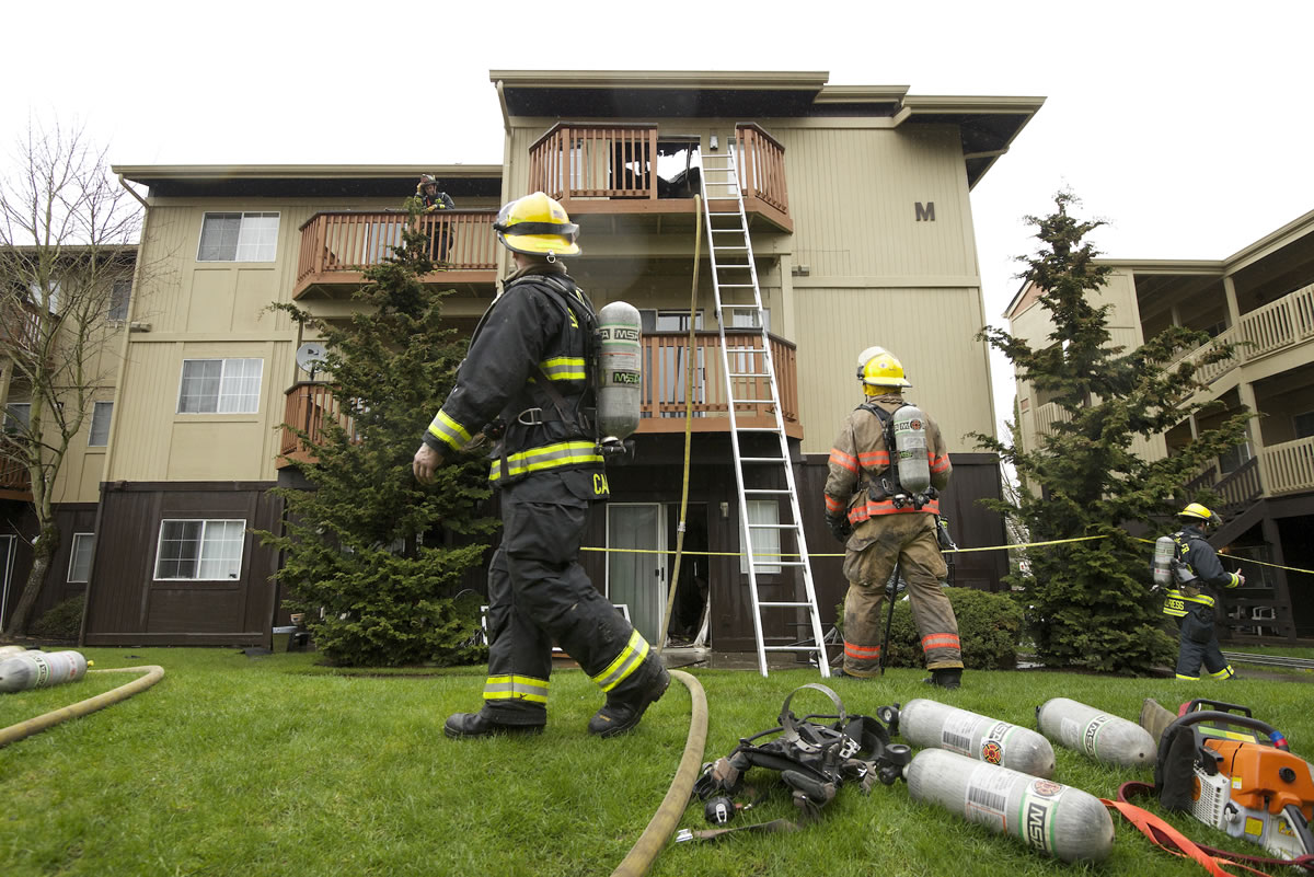 Firefighters clean up after a fire damaged an apartment complex at the Bridge Creek apartments on Sunday in Hazel Dell.