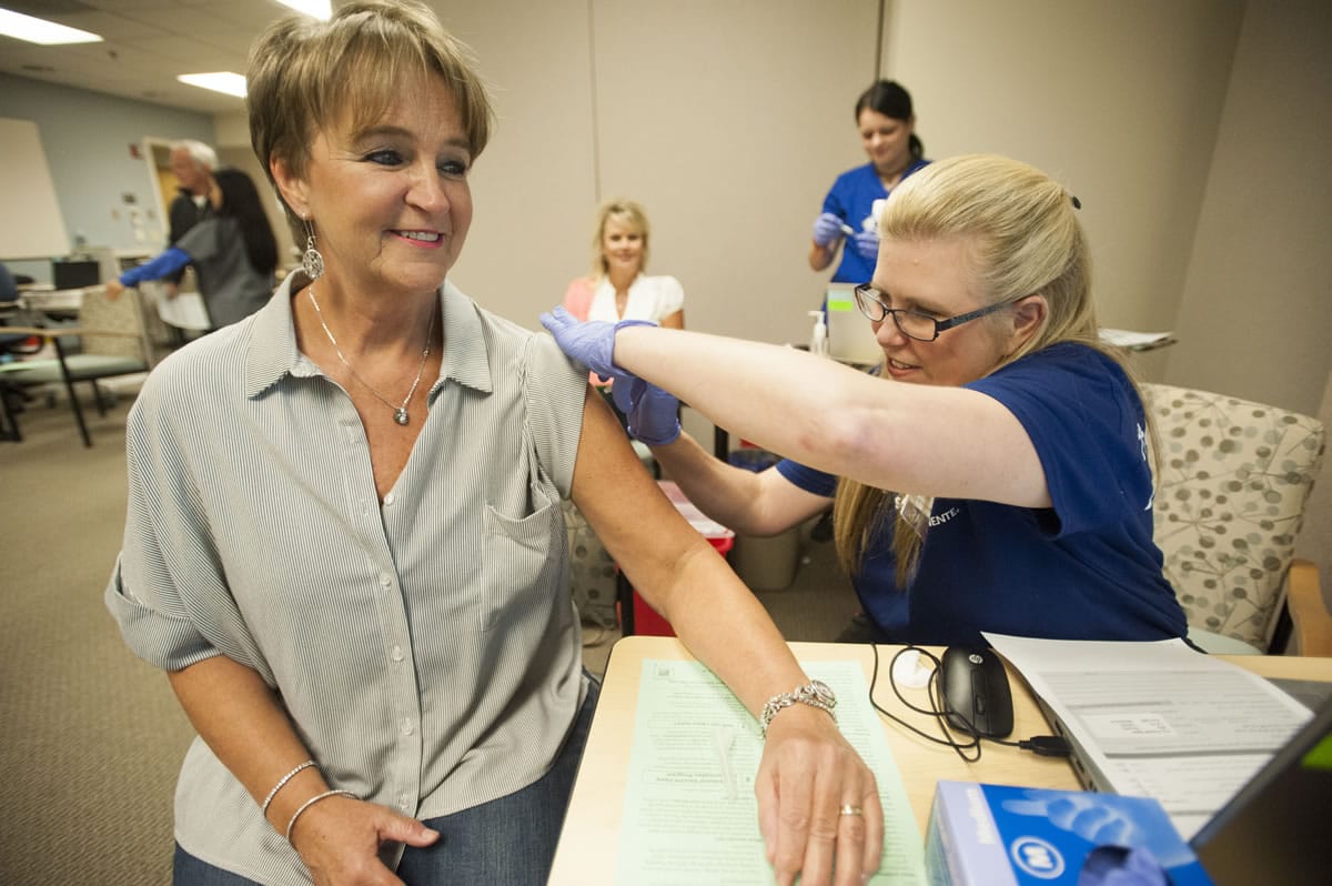 Dena Tornow gives patient Jackie Hadder a flu shot during a flu vaccine clinic Thursday at Kaiser Permanente Salmon Creek Medical Office. Health officials are urging people to get their flu shot soon, before the flu begins circulating.
