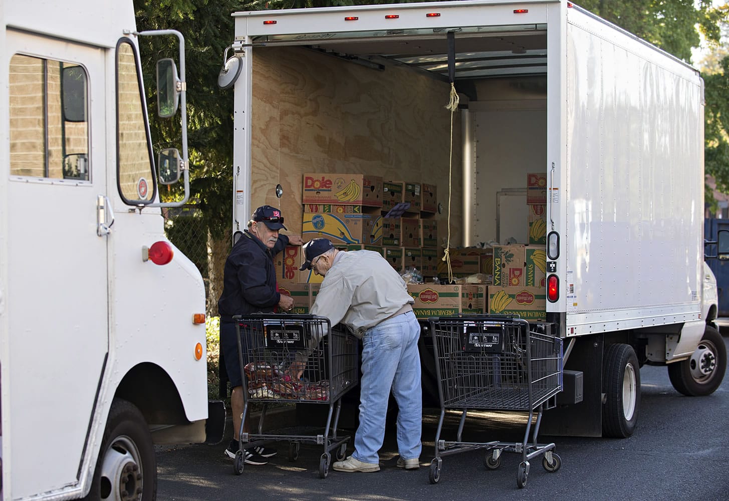Salvation Army volunteers Greg Puppo, left, and Bill Davis, load up donated bakery items into their truck Tuesday at the Salmon Creek Safeway.