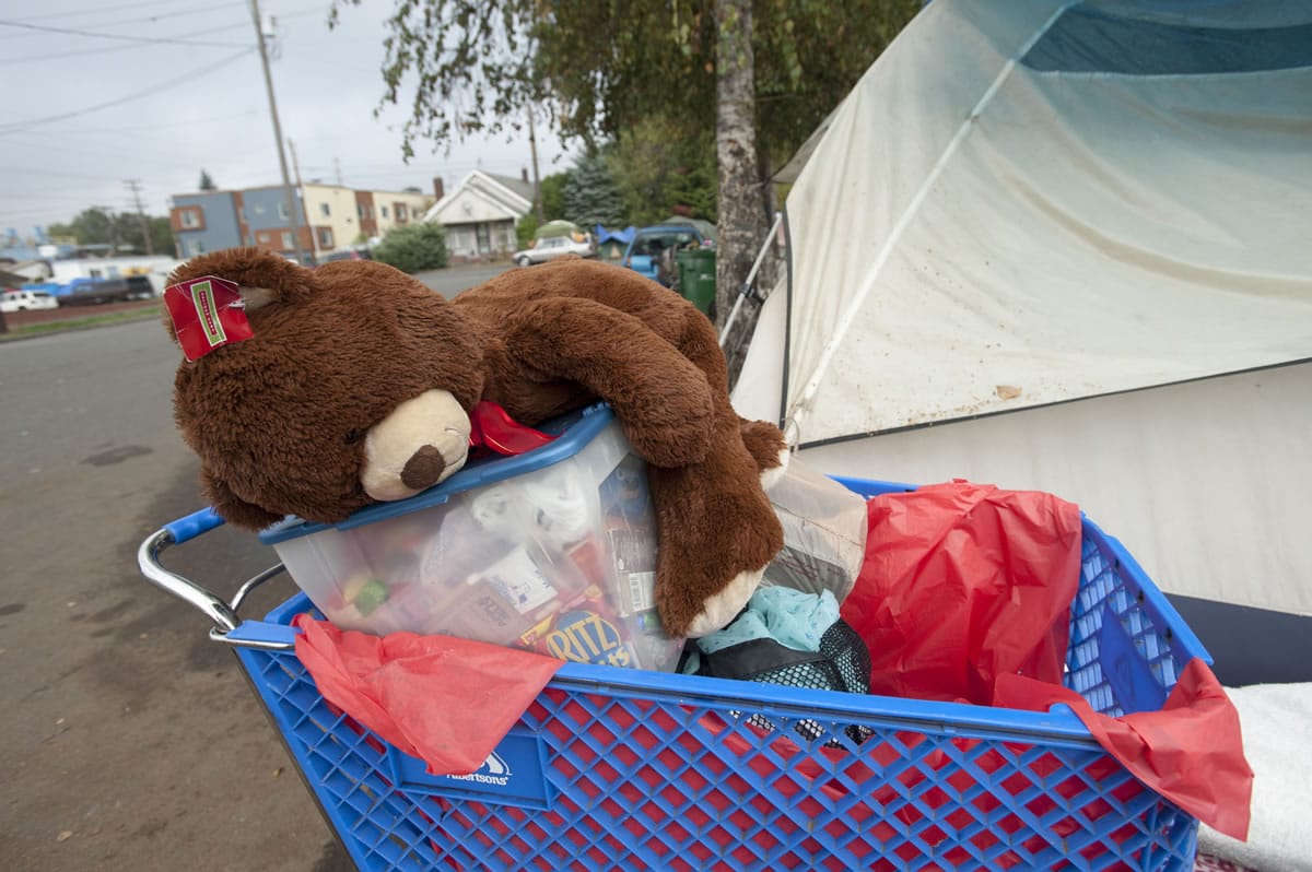 A teddy bear is among the possessions loaded in a shopping cart beside a tent Wednesday in west Vancouver.