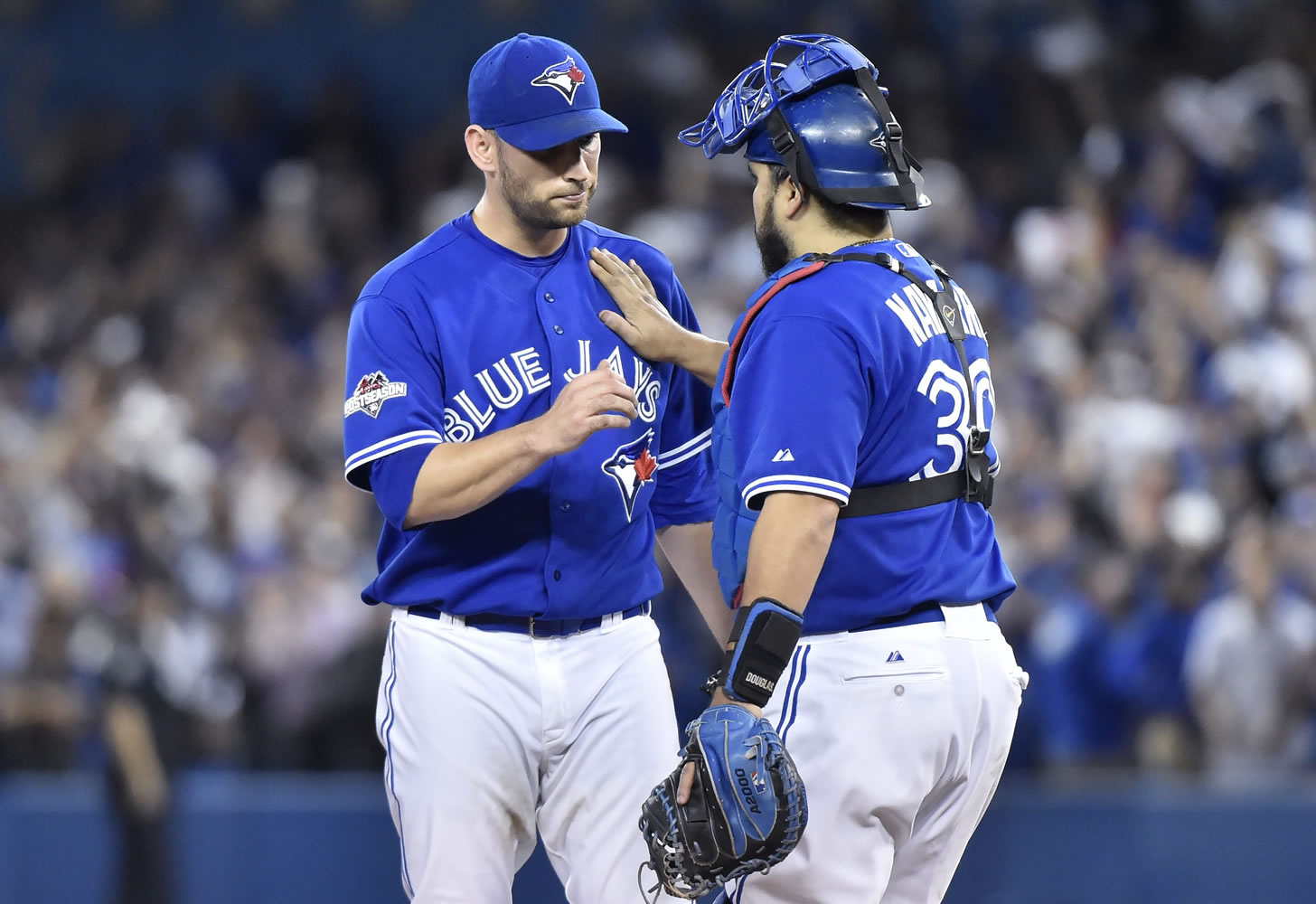 Toronto Blue Jays'  starting pitcher Marco Estrada is congratulated by catcher Dioner Navarro after being pulled from the game against the Kansas City Royals during the eighth inning in Game 5 of baseball's American League Championship Series on Wednesday, Oct. 21, 2015, in Toronto.