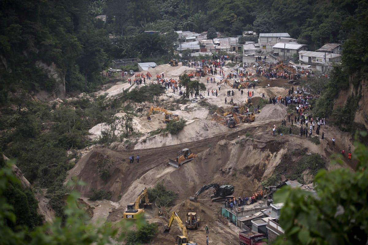 Rescue workers search for survivors Friday after a landslide hit Cambray, a neighborhood in the suburb of Santa Catarina Pinula, about 10 miles east of Guatemala City. The hill that towers over Cambray collapsed late Thursday after heavy rains.