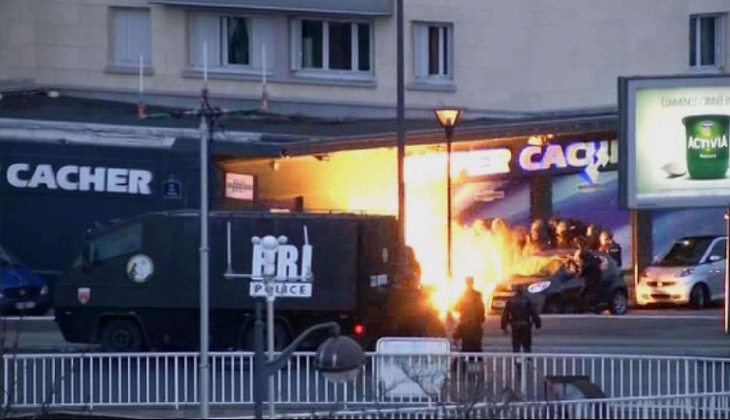 Police officers storm a kosher grocery to end a hostage situation in this image made from TV in Paris, Friday, Jan. 9, 2015.