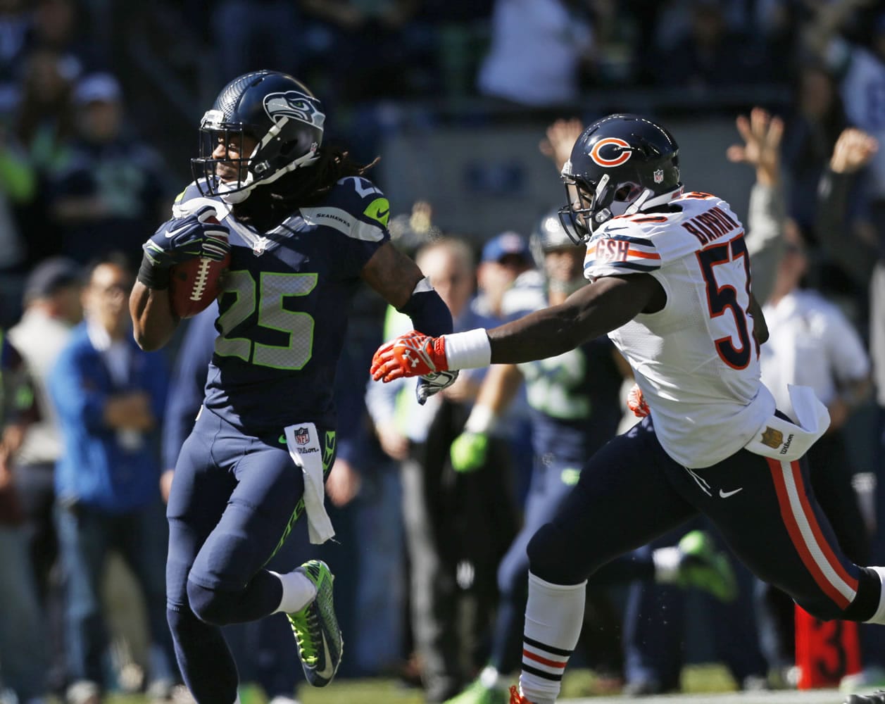 Seattle Seahawks cornerback Richard Sherman (25) carries the ball during a 64-yard punt-return run as Chicago Bears linebacker Lamin Barrow, right, pursues in the first half of an NFL football game, Sunday, Sept.