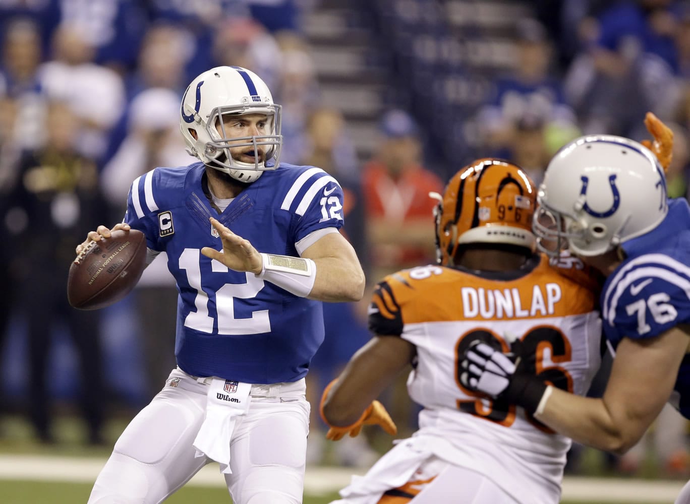 Indianapolis Colts quarterback Andrew Luck, left, looks to throw as Colts' offensive guard Jack Mewhort, right, blocks Cincinnati Bengals defensive end Carlos Dunlap during the first half Sunday, Jan. 4, 2015, in Indianapolis.