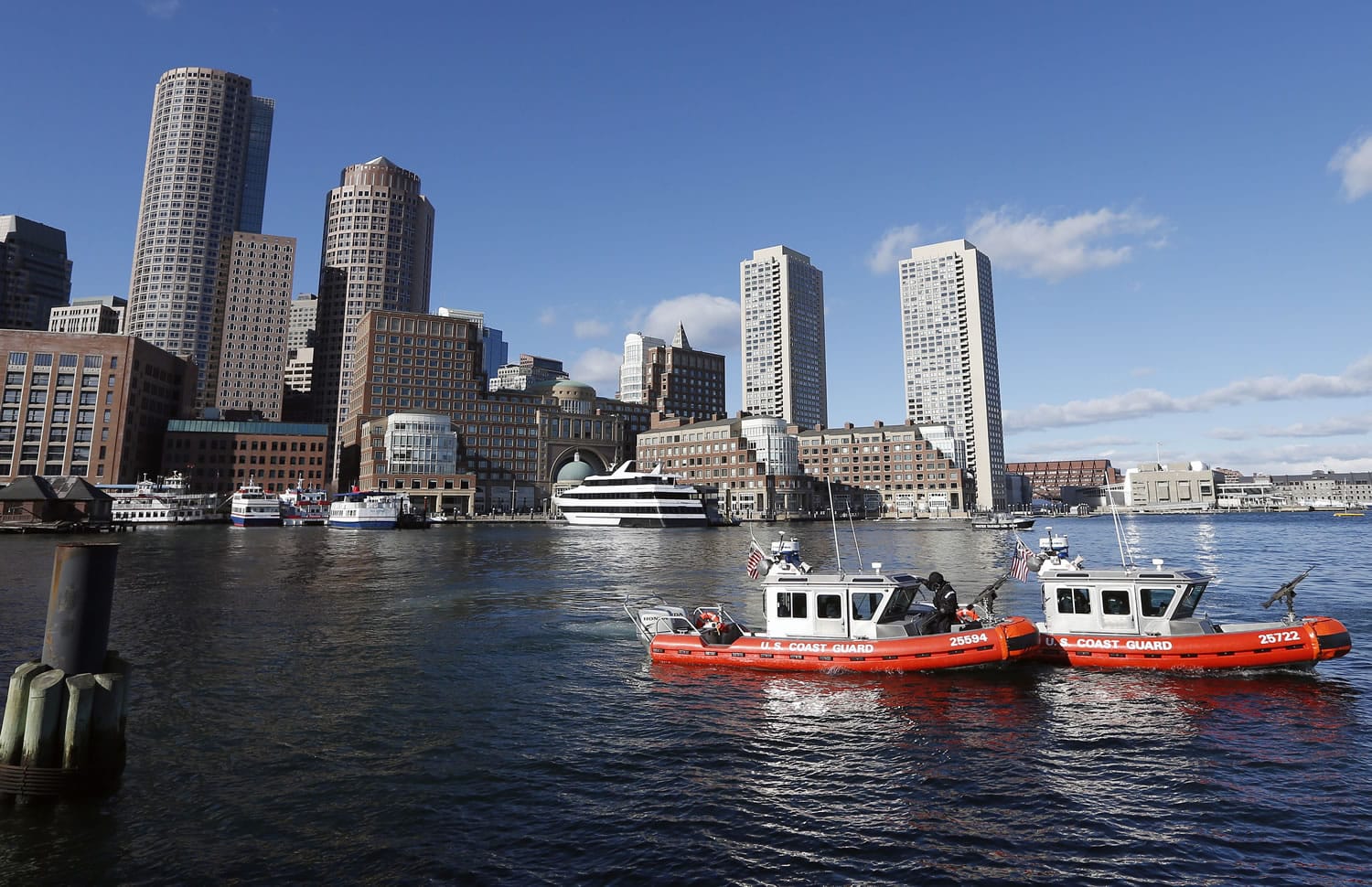 U.S. Coast Guard boats patrol the Boston Harbor outside the federal courthouse, Monday, Jan. 5, 2015, in Boston, during the first day of jury selection in the trial of Boston Marathon bombing suspect Dzhokhar Tsarnaev.