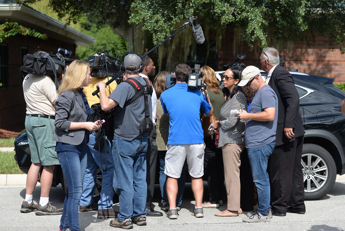 The car of Terrence Meadows, a merchant marine, is surrounded by the press Monday as he stops to answer questions on his way to a gathering in Jacksonville, Fla., for the families of the El Faro crew.