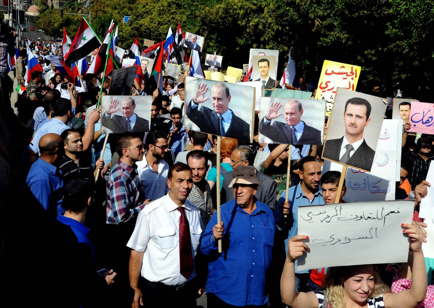 Syrians hold photos of Syrian President Bashar Assad and Russian President Vladimir Putin, during a rally to thank Moscow for its intervention in Syria, in front of the Russian embassy in Damascus, Syria, Tuesday, Oct. 13, 2015. Insurgents fired two shells at the Russian embassy in the Syrian capital on Tuesday as hundreds of pro-government supporters gathered outside the compound to thank Moscow for its intervention in Syria.
