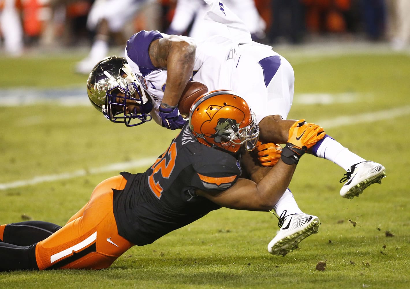 Washington's Dwayne Washington is tackled by Oklahoma State's Ryan Simmons during the Cactus Bowl on Friday, Jan. 2, 2015, in Tempe, Ariz.