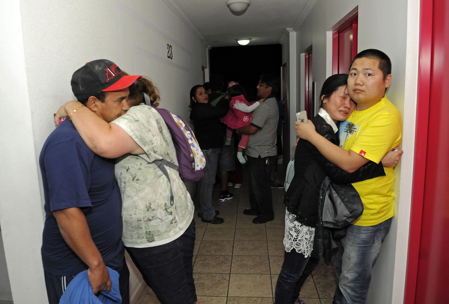 People embrace Tuesday on the upper floor of an apartment building a few blocks from the coast in Iquique, Chile, having gathered for safety in case of a tsunami after a magnitude-8.2 earthquake.