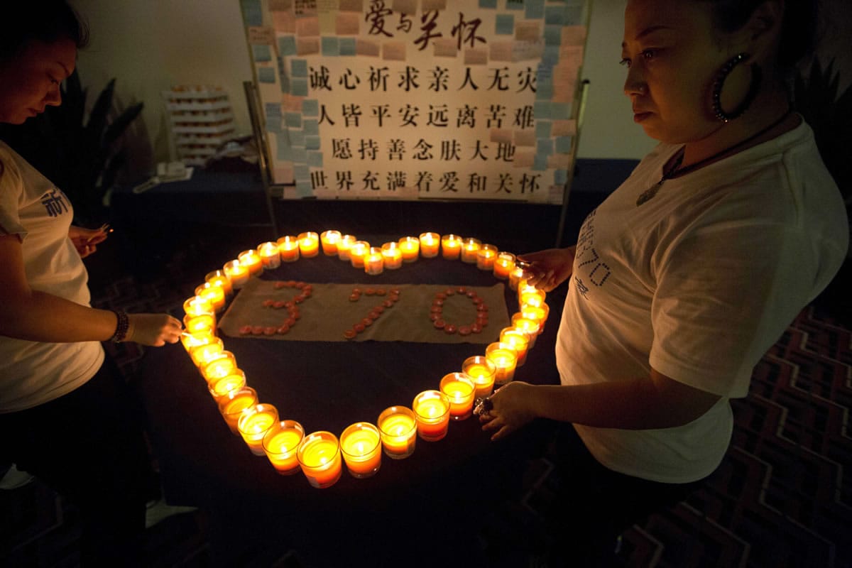 Relatives of Chinese passengers on board the Malaysia Airlines Flight MH370 lit candles in a prayer room Friday in Beijing.