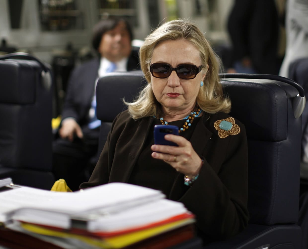 Then-Secretary of State Hillary Rodham Clinton checks her Blackberry in 2011 from a desk inside a C-17 military plane upon her departure from Malta, in the Mediterranean Sea, bound for Tripoli, Libya.