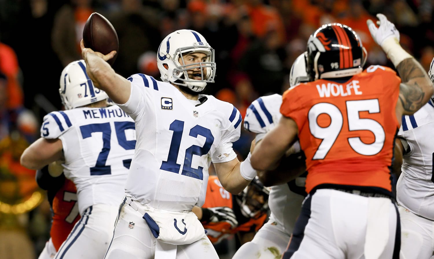 Indianapolis Colts quarterback Andrew Luck, left, throws under pressure from Denver Broncos defensive end Derek Wolfe during the second half of an NFL divisional playoff game, Sunday, Jan. 11, 2015, in Denver.