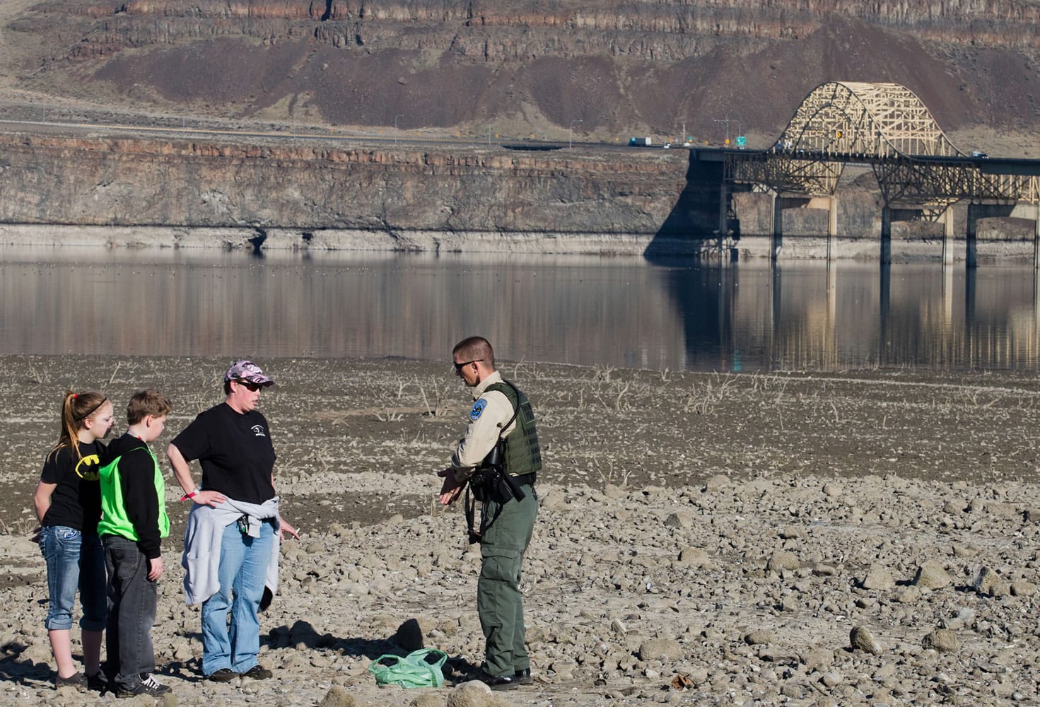 Washington State Department of Fish &amp; Wildlife officer Will Smith warns Talena Hunter of Ellensburg, and her two children, to stay off the exposed beach area along the Columbia River on Wednesday.