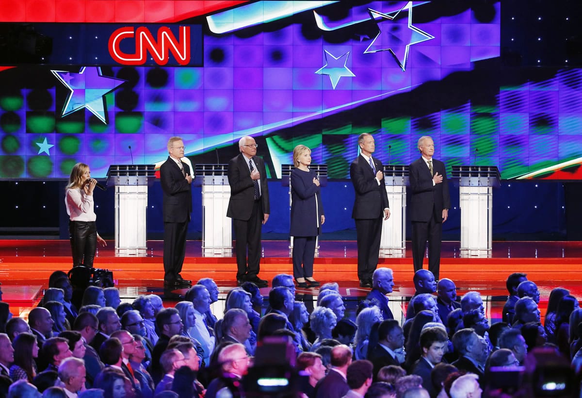 Sheryl Crow, left, sings the National Anthem as Democratic presidential candidates, from left, former Virginia Sen. Jim Webb, Sen. Bernie Sanders, of Vermont, Hillary Rodham Clinton, former Maryland Gov. Martin O&#039;Malley, and former Rhode Island Gov. Lincoln Chafee take the stage before the CNN Democratic presidential debate Tuesday in Las Vegas.