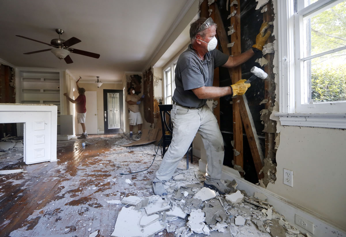 Bryan Allen works to remove wet drywall from a friend&#039;s flood-damaged home Thursday in Columbia, S.C.
