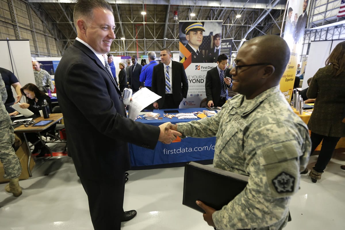 Joe Wilhelm, left, a recruiter with payment processing company First Data Corp., shakes hands Oct. 23 with U.S. Army Spc. Vincent Knowles at a job fair that was part of a &quot;transition summit&quot; intended to provide employment and educational information to soldiers who may exit military service in the next year, at Joint Base Lewis-McChord near Tacoma. The Labor Department reported Friday that 2014 was the best year for hiring in the U.S. in 15 years. (AP Photo/Ted S.