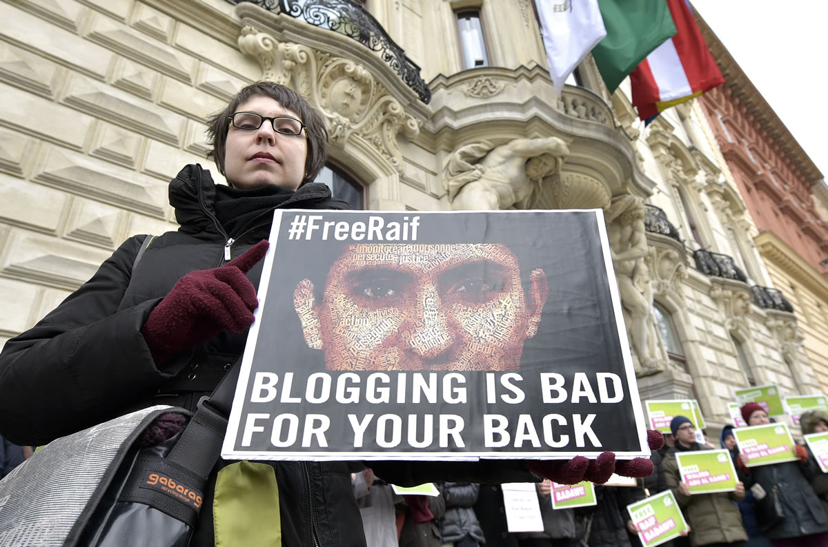 FILE - In this Friday, Feb. 6, 2015 file photo, members of the Austrian Greens attend a protest against the detainment of Saudi blogger Raif Badawi in front of the KAICIID in Vienna, Austria. A Saudi blogger sentenced to 10 years in prison and 1,000 lashes for insulting Muslim clerics has won the European Union?s prestigious Sakharov Prize for human rights. Raif Badawi was honored with the award as a symbol of the fight for freedom of speech - an announcement greeted with a standing ovation Thursday, Oct, 29, 2015 at the European Parliament assembly in Strasbourg, France. ?I urge the king of Saudi Arabia to free him, so he can accept the prize,? Parliament President Martin Schulz said.