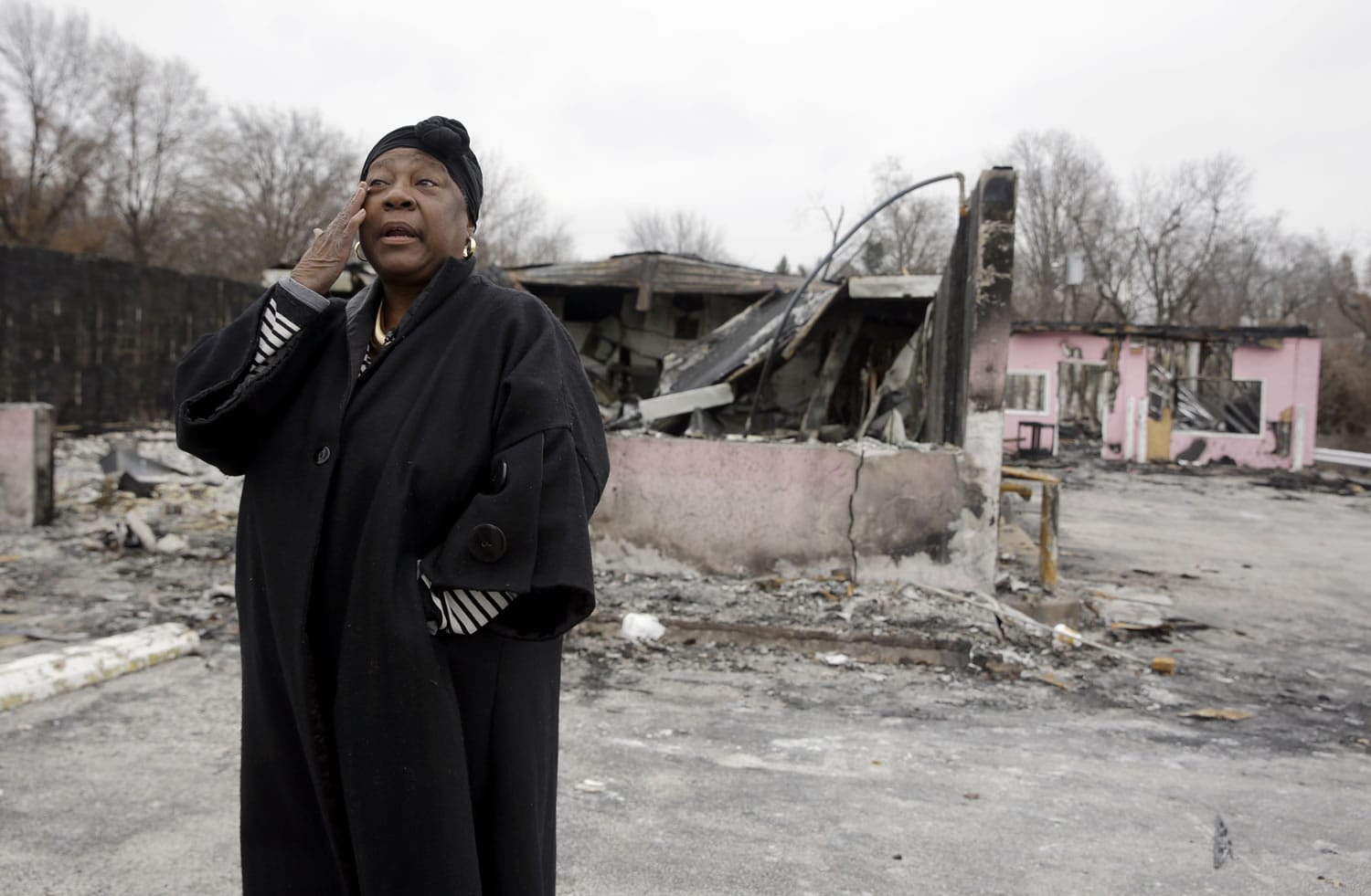Juanita Morris wipes her eye outside the remains of her burned-out business on Dec. 9 in Dellwood, Mo. On the morning of Nov. 24, Juanita's Fashions R Boutique opened for business as usual.