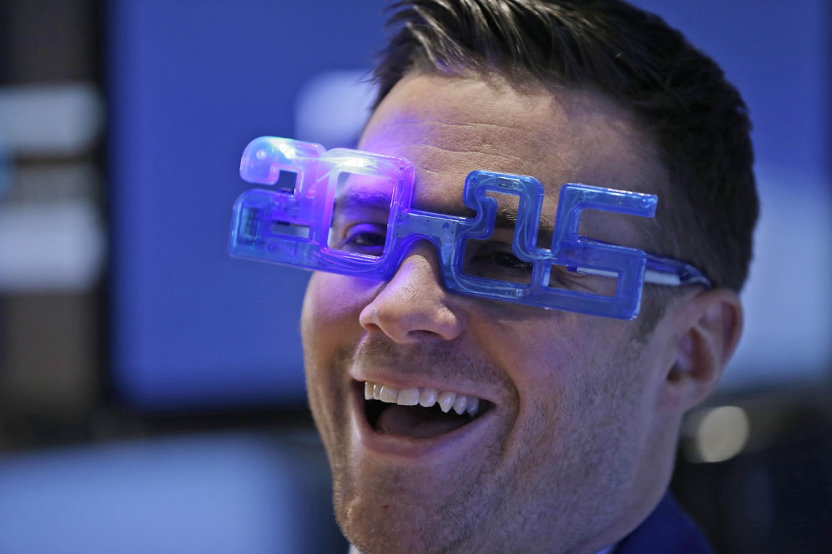 A trader smiles while working on the floor at the New York Stock Exchange in New York, Wednesday, Dec. 31, 2014.
